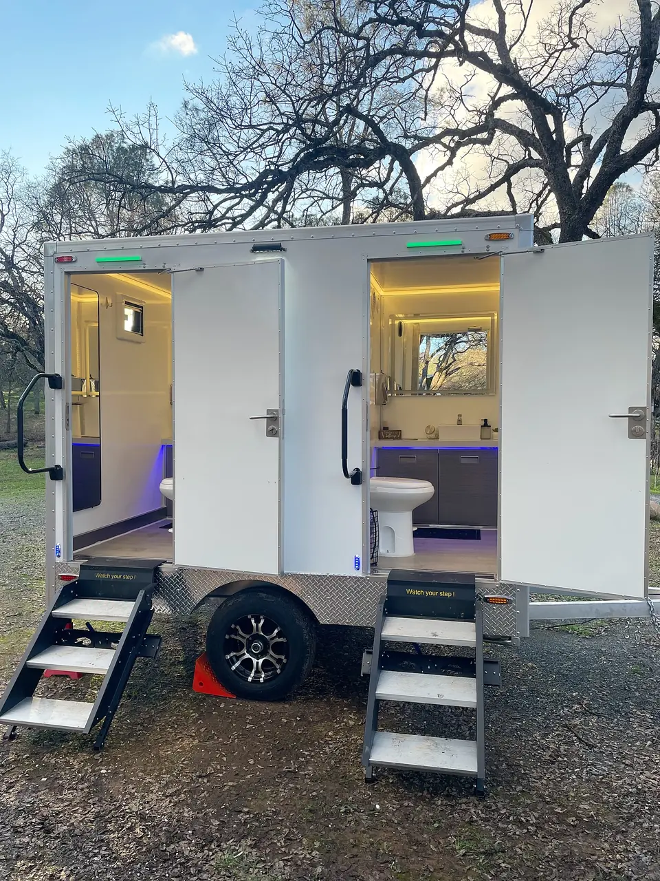 Restroom trailer with both doors open and lights on