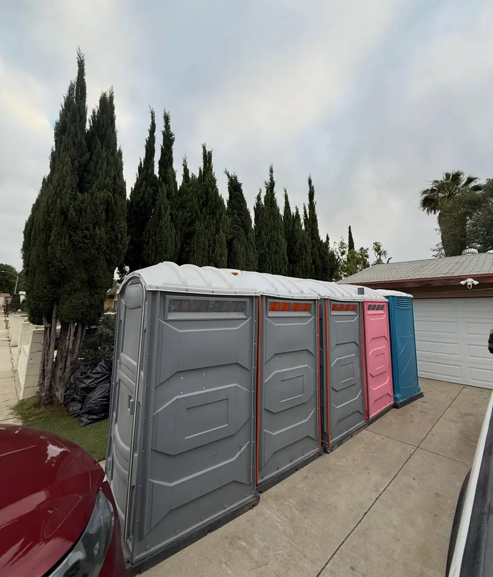 A row of event porta potties staged on a driveway.