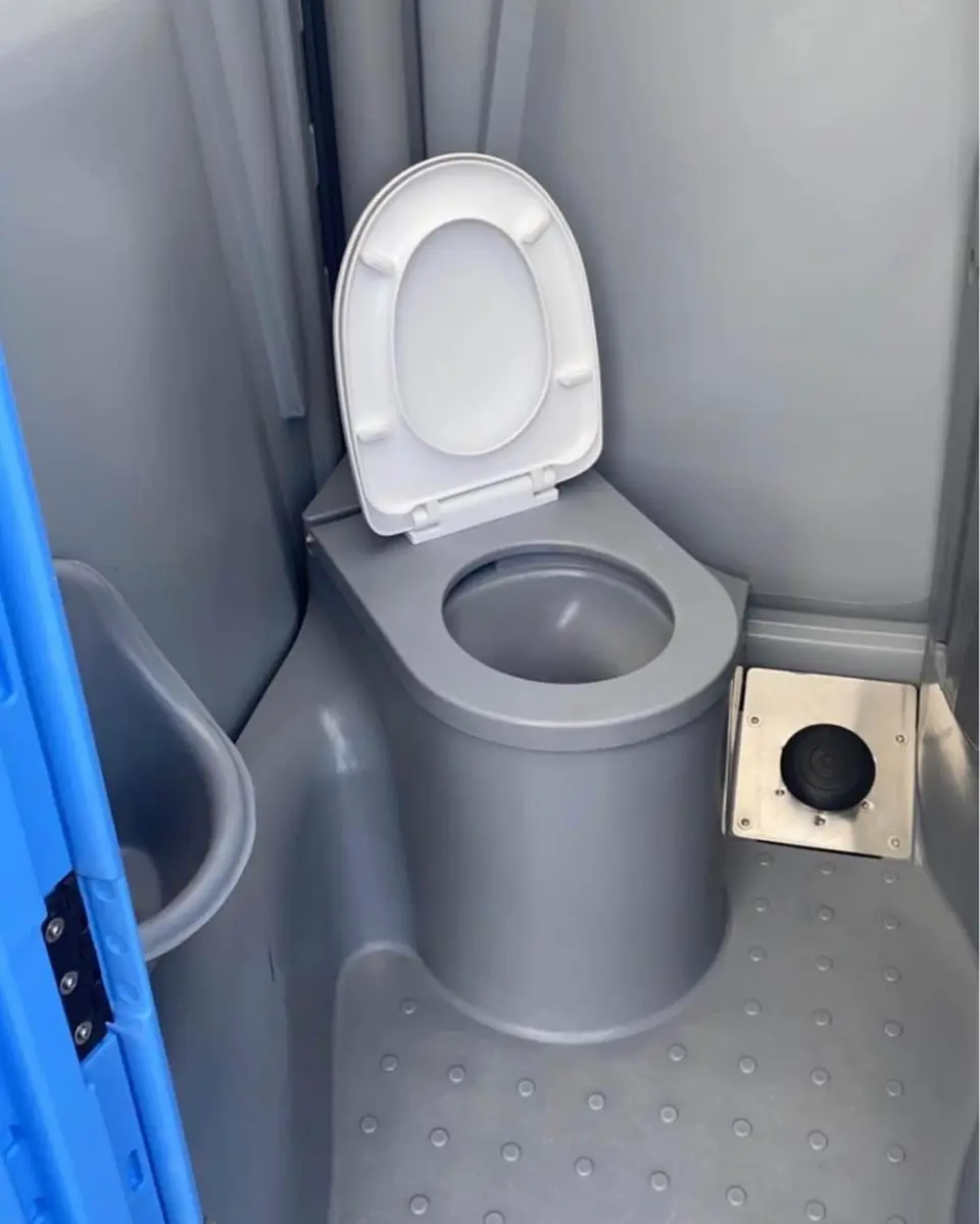 Porta potty toilet seat beside a hand sanitizer dispenser
